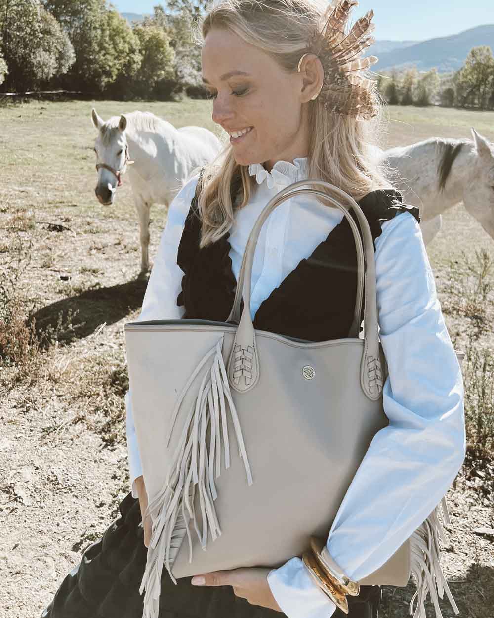 Muje rubia con bolso beige shopper con flecos
