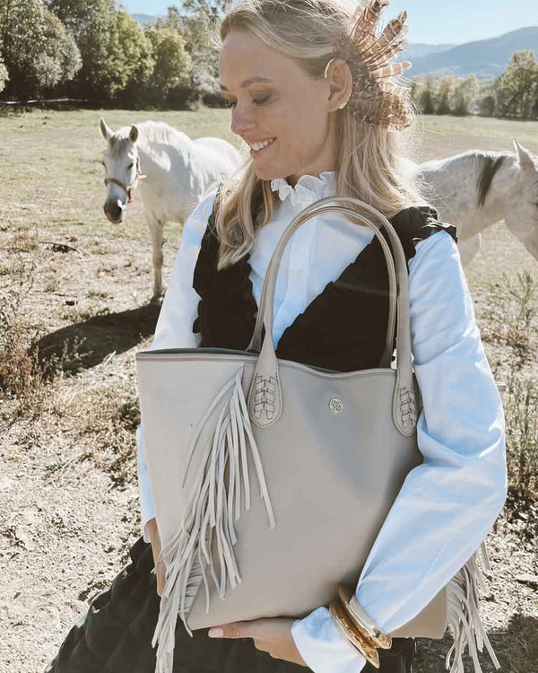 Muje rubia con bolso beige shopper con flecos